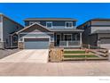 Inviting two-story home with a charming front porch and well-kept lawn, complemented by a neat fence at 11933 Norfolk Ct, Commerce City, CO 80022