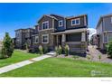 Attractive two-story home showcasing a welcoming front porch and lush lawn on a clear day at 11933 Norfolk Ct, Commerce City, CO 80022
