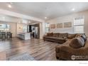 Spacious living room features an open floor plan, wood floors, and abundant natural light from multiple windows at 11933 Norfolk Ct, Commerce City, CO 80022