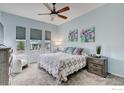 Comfortable bedroom with decorative pillows, matching nightstands, and natural light from three windows at 14394 W 88Th Dr # C, Arvada, CO 80005