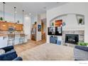 Cozy living room featuring a fireplace, media center, and open concept to the kitchen with breakfast bar seating at 14394 W 88Th Dr # C, Arvada, CO 80005