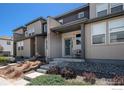 Inviting townhome exterior featuring a well-kept lawn and charming facade at 16058 E Elk Dr, Denver, CO 80239