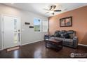 Cozy living room with dark wood floors, a ceiling fan, and a comfortable couch at 16058 E Elk Dr, Denver, CO 80239