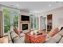 Sun-filled living room with fireplace, wood floors, and balcony access at 2050 Walnut St, Boulder, CO 80302