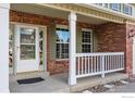 Inviting front porch features white railings and brickwork, adding to the home's curb appeal at 2822 Flint Ct, Superior, CO 80027