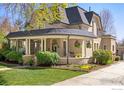 Lovely home featuring a covered front porch with hanging flower baskets and a beautifully landscaped yard at 318 Pratt St, Longmont, CO 80501