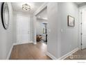 Bright entryway with hardwood floors and a view into a cozy seating area at 3295 Heron Lakes Pkwy, Berthoud, CO 80513