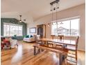 Open-concept living area with hardwood floors, natural light, comfortable seating and a large dining table at 3338 Auklet Dr, Berthoud, CO 80513
