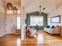 Inviting living room with hardwood floors, large windows, comfortable seating, and stylish decor at 3338 Auklet Dr, Berthoud, CO 80513