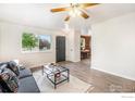 Spacious living room featuring wood floors, a glass coffee table, and a bright window view at 417 E 4Th Ave, Longmont, CO 80504