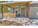 Inviting front porch with wood columns, stone accents, and decorative front door at 4337 San Marco Dr, Longmont, CO 80503