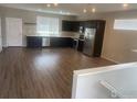 Open-concept kitchen with dark cabinets, stainless steel appliances, and laminate flooring at 4672 Clear Creek Dr, Longmont, CO 80504
