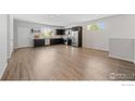 Bright, open floorplan with modern kitchen appliances, dark cabinets, and light wood-look flooring at 4672 Clear Creek Dr, Longmont, CO 80504