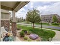 Relaxing front porch with stone columns and manicured landscaping at 4784 Raven Run, Broomfield, CO 80023