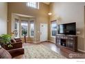Bright living room features hardwood floors, tall ceilings and large windows at 4784 Raven Run, Broomfield, CO 80023