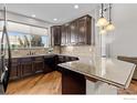 Modern kitchen features dark cabinets, granite countertops, stainless steel appliances and ample counter space at 4822 Raven Run, Broomfield, CO 80023