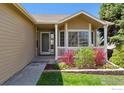 Inviting front porch with white railing and colorful landscaping, adding curb appeal to this charming home at 4835 Egret Dr, Frederick, CO 80504
