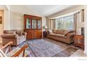 Cozy living room with a large bay window, hardwood furniture, and neutral tones for a relaxing space at 4835 Egret Dr, Frederick, CO 80504