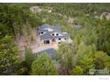 Secluded home nestled in a lush forest setting with a long private driveway and garages at 50 Wildwood Ln, Boulder, CO 80304