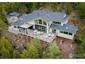 Aerial view of modern home with large deck overlooking a wooded landscape at 50 Wildwood Ln, Boulder, CO 80304