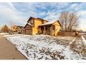 Exterior angle view of home featuring a front porch, showcasing snow-covered yard at 548 Mathews Cir, Erie, CO 80516
