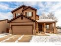 Two-story home featuring a front porch with stone accents and a two car garage at 548 Mathews Cir, Erie, CO 80516