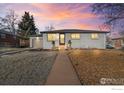 Charming, white, one-story home with well-maintained landscaping and a quaint front walkway, during sunset at 8861 Hastings Way, Westminster, CO 80031