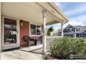 Inviting covered porch with seating, offering a relaxing outdoor space at 914 Snowberry St, Longmont, CO 80503