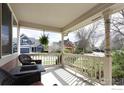 Charming porch view with wicker seating and a glimpse of the neighborhood at 914 Snowberry St, Longmont, CO 80503