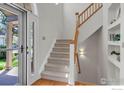 Bright foyer featuring a staircase with wooden banister and a view to the outside at 100 Springs Cv, Louisville, CO 80027