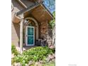 Close-up of the front porch with stone detailing and a charming seating arrangement at 100 Springs Cv, Louisville, CO 80027