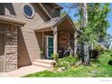 Inviting front porch featuring stone accents, a cozy seating area, and lush landscaping at 100 Springs Cv, Louisville, CO 80027
