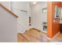 Bright foyer with hardwood floors, white walls and door, and stairs leading up to the second floor at 1025 Neon Forest Cir, Longmont, CO 80504