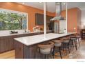 Modern kitchen boasts stainless steel appliances, white countertops, stylish bar stools, and natural light at 1025 Neon Forest Cir, Longmont, CO 80504