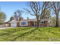 Well-maintained single-story brick home with a lush lawn and mature trees providing ample shade at 10340 W 34Th Ave, Wheat Ridge, CO 80033