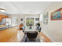 Bright dining area with wood floors, a glass table, and sliding doors to the outdoor deck at 106 Starline Ave, Lafayette, CO 80026