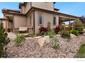 Detailed landscaping featuring rock beds, shrubs, and a bench on a patio at 1105 Shelby Dr, Berthoud, CO 80513