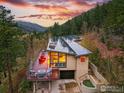 Beautiful home with a deck overlooking lush forestry, mountains, and a captivating sunset at 1127 Valley Ln, Boulder, CO 80302