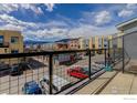View from a balcony with multiple townhouses, a parking lot, and mountains in the background at 1200 Yarmouth Ave # 238, Boulder, CO 80304