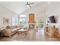 Bright living room with a fireplace, hardwood floors, and a ceiling fan at 1271 Hickory Dr, Erie, CO 80516