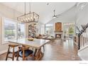 Open-concept living room with vaulted ceilings, hardwood floors, fireplace, and modern lighting at 1271 Hickory Dr, Erie, CO 80516