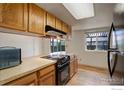 Functional kitchen with wood cabinets and updated black appliances at 13580 Eliot Ct, Broomfield, CO 80020