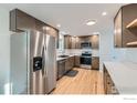 Modern kitchen with stainless steel appliances, stylish cabinets, and beautiful hardwood floors at 1430 Lashley St, Longmont, CO 80504