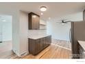 Bright kitchen with modern cabinets, stainless steel refrigerator, open shelves, and hardwood floors at 1430 Lashley St, Longmont, CO 80504