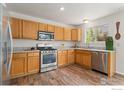 Kitchen features stainless steel appliances, wood cabinets, tile countertops, and a window overlooking the yard at 1842 Reliance Cir, Superior, CO 80027