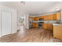 Bright kitchen featuring wood cabinets and stainless steel appliances with an open view to the living room at 1842 Reliance Cir, Superior, CO 80027