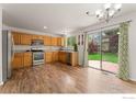 Bright kitchen featuring wood cabinets, stainless steel appliances, and a sliding glass door to the backyard at 1842 Reliance Cir, Superior, CO 80027