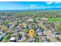Expansive aerial view of a residential neighborhood with tree-lined streets and community amenities at 19 University Cir, Longmont, CO 80503