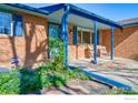 Inviting brick home featuring a charming covered front porch and well-maintained landscaping at 19 University Cir, Longmont, CO 80503