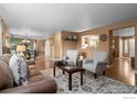 Inviting living room featuring a brown sofa, armchairs, decorative rug, and open floor plan at 2085 E 127Th Pl, Thornton, CO 80241